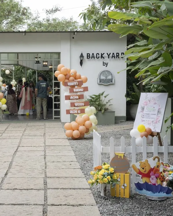 Welcome to the Hundred Acre Wood! The entrance to this Winnie the Pooh party at a beautiful farmhouse venue featured a rustic directional sign and Pooh-themed props.