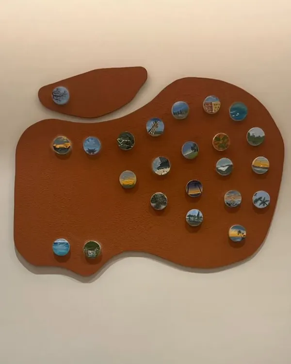 This is the "Our Memories" piece, a custom travel story canvas created for a family of avid travelers. The apple-shaped board serves as a unique backdrop for over twenty miniature paintings of their favorite destinations.