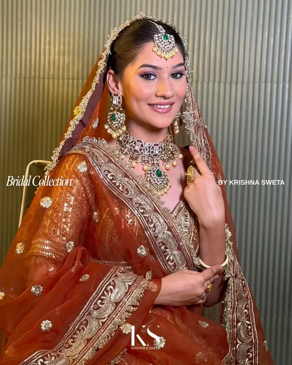 A radiant bride adorned in our complete Kundan bridal set. This look, featuring a statement choker, matching earrings, and maang tikka with emerald green accents, embodies the timeless elegance I strive for in every piece.