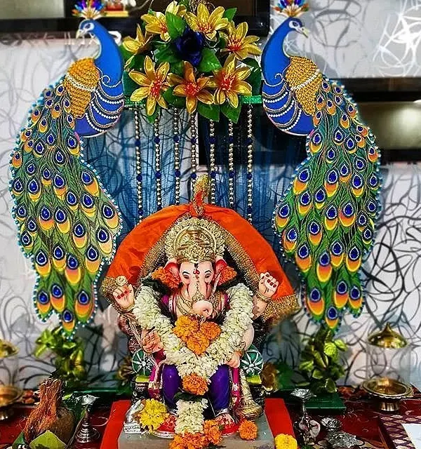 This grand peacock-themed decoration is one of my signature styles for welcoming Ganpati Bappa. I used vibrant, detailed peacock cutouts and floral arrangements to create a majestic throne, making it a stunning centerpiece for your home festival.