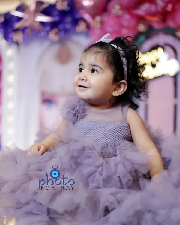 A close-up portrait of the birthday girl, her bright smile and the soft details of her lavender party dress perfectly captured. This is the kind of timeless shot I aim for during kids' photoshoots in Delhi.