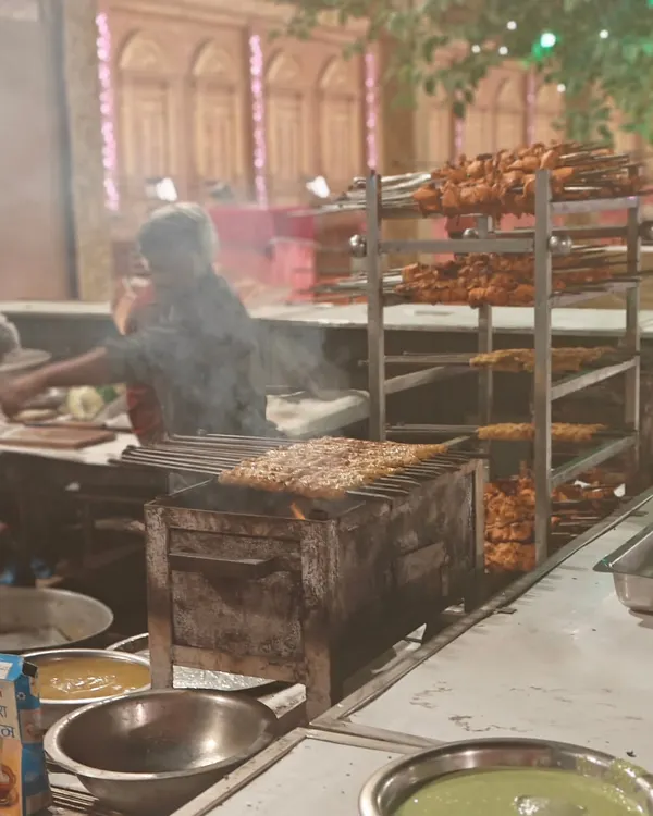 Our live kebab station in full swing. The smoke and aroma of freshly grilled chicken tikkas and seekh kebabs create a fantastic atmosphere at any party.