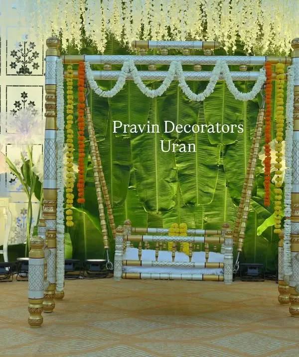 This is a full view of a naming ceremony stage I designed. The centerpiece is the traditional palna, decorated with marigold and jasmine garlands, set against a fresh banana leaf backdrop and white floral panels.
