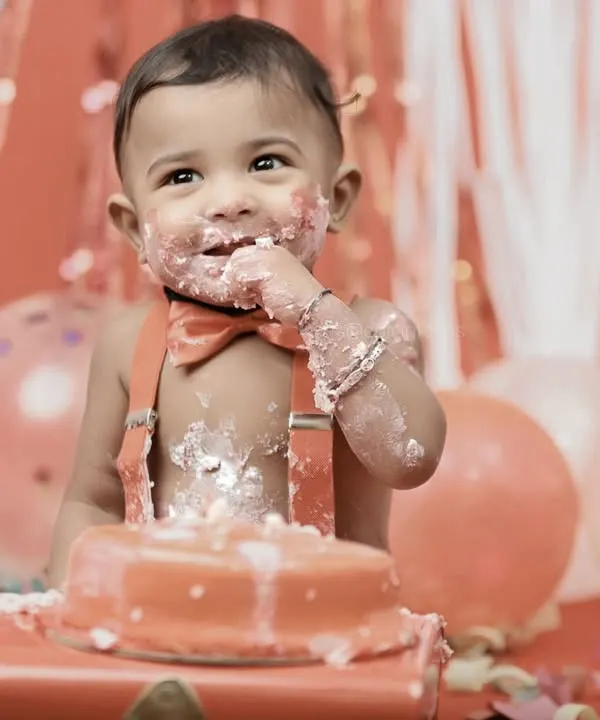 There's nothing quite like the moment they first taste the cake. This close up captures the pure delight and sweet mess of a first birthday cake smash session.