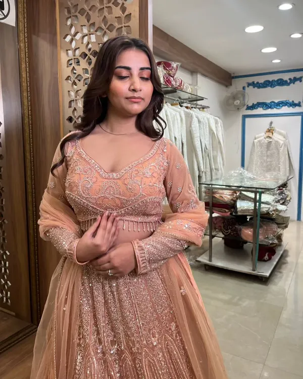 A lovely peach-colored lehenga with all-over silver embroidery. This pre-loved piece is elegant and perfect for a daytime wedding or engagement.