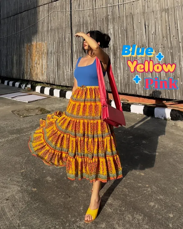 A perfect summer color combination for my brown girlies: blue, yellow, and pink. This vibrant tiered skirt paired with a simple blue tank top and a pink bag is a great example of joyful color blocking.