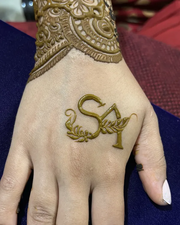 A close-up of the personalized initials "SA" on the back of the hand, a beautiful and elegant touch for any bride.