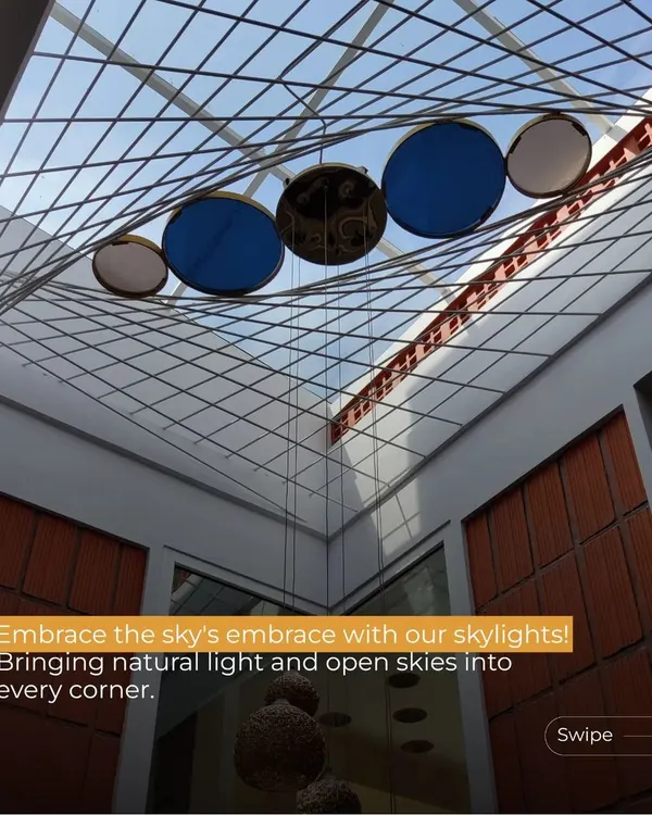 This skylight at the Gopal Residence is a centerpiece of the design. The suspended blue and white discs interact with the sunlight, creating a celestial effect while bathing the double-height space in a soft, diffused glow.