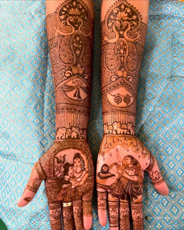 This is what I mean by telling your story. This royal wedding design features a beautiful portrait of Shiva and Parvati on the palms, surrounded by intricate patterns, elephants, and the couple's initials, creating a truly divine and personalized bridal mehendi.