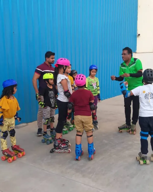 A young group of skaters listening to instructions before practice. I make sure every child is equipped with proper safety gear like helmets and knee pads before we start any session on the court.
