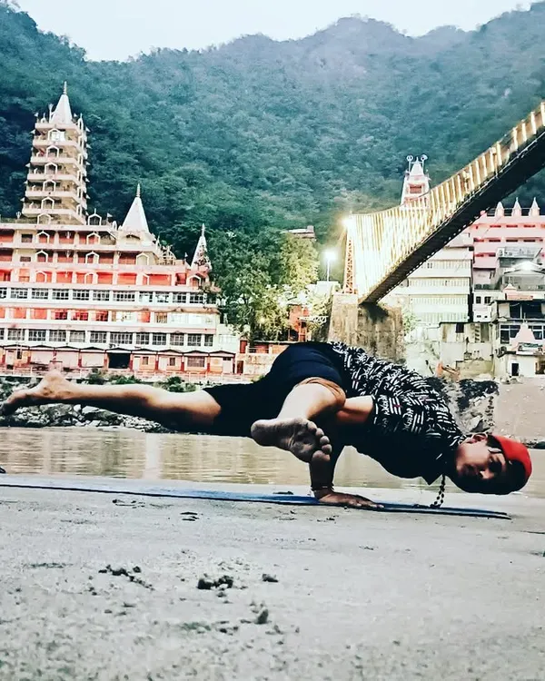Here I am in Ek Paad Koundinyasana in Rishikesh. This advanced arm balance requires and builds significant core and upper body strength, along with hip flexibility.