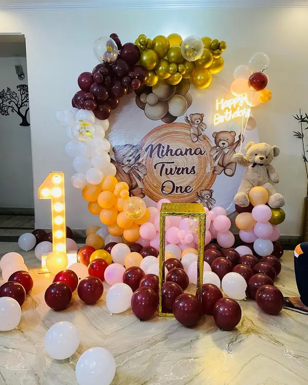 A warm and inviting teddy bear theme for Mihana's first birthday. This setup features a custom backdrop, a large light-up number '1', a teddy bear prop, and a balloon arch in rich, earthy tones.