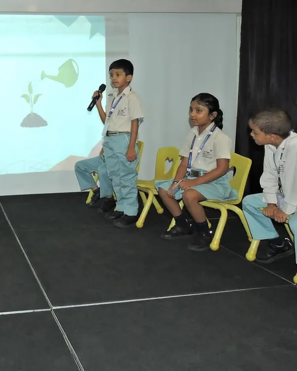 A student confidently takes the microphone during our "Buzzathon" spelling competition. We create opportunities like this to help children build vocabulary and gain confidence in public speaking.