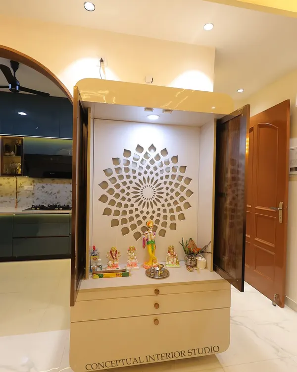 A minimalist and modern mandir design. This compact unit features a beautiful back-lit jali panel and drawers for storage, fitting perfectly in a small nook.