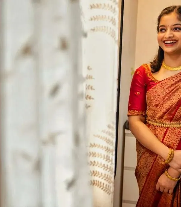A candid shot of the bride-to-be, smiling with joy at her engagement ceremony. The makeup is minimal and elegant, focusing on a 'second skin' finish to let her natural beauty shine through.