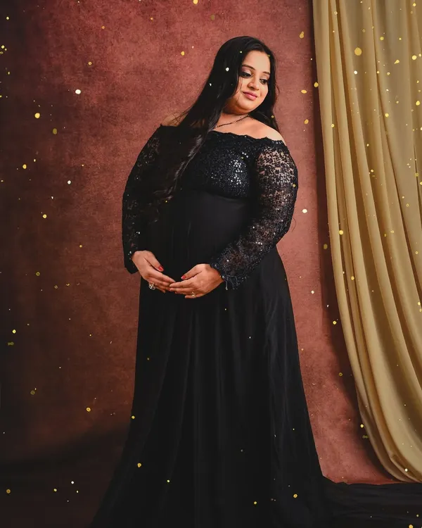 A classic solo portrait featuring one of our black off-shoulder lace gowns. The warm lighting and subtle sparkle effect add a touch of magic to the image.