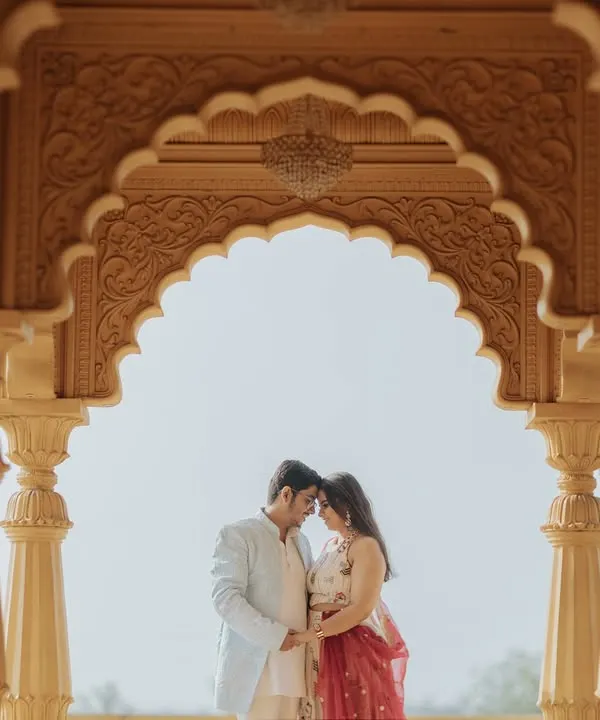 An intimate moment framed perfectly by the intricate arches of a palace. This composition uses architecture to create a naturally beautiful and romantic portrait.