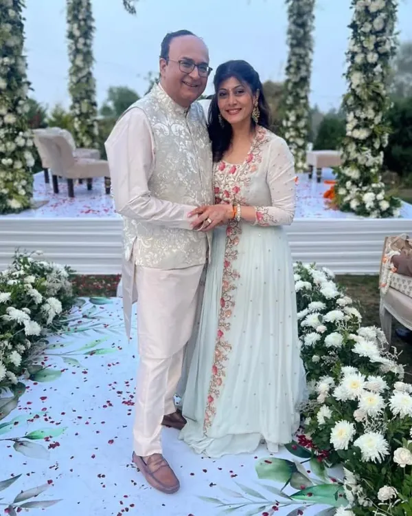 A valued client at an outdoor wedding, wearing a bespoke Nehru jacket in a light, subtly patterned fabric over a silk kurta. This piece was crafted to radiate elegance and sophistication.