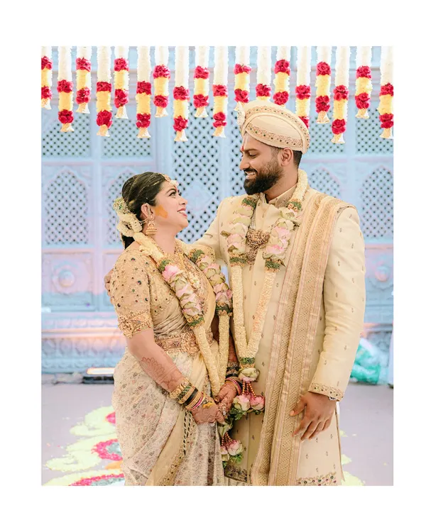 A beautiful, candid moment between the bride and groom, Diana and Pavan. Her custom gold-embroidered blouse and his elegant sherwani were designed to create a harmonious look.