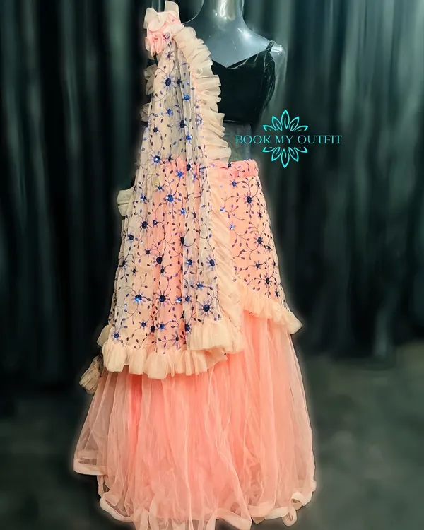 For a modern look at a reception or sangeet, I have this beautiful peach ruffled lehenga. The tiered skirt and embroidered dupatta create a contemporary silhouette.