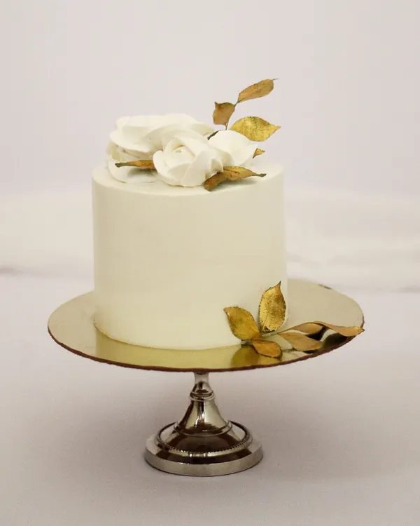 Sometimes, the simplest designs are the most elegant. This minimalist cake features a smooth white finish, accented with delicate white chocolate roses and hand-painted gold leaves. It’s a perfect centerpiece for an intimate wedding, engagement, or a special anniversary.