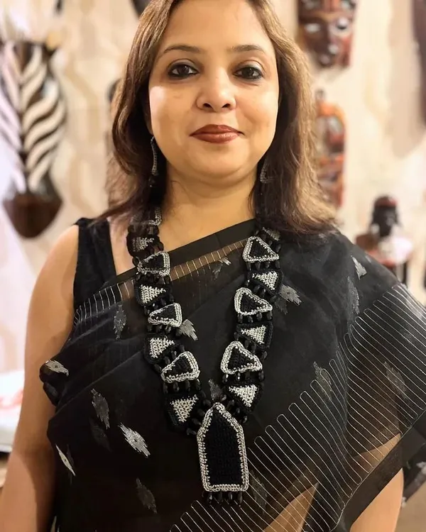 This custom-designed geometric necklace, seen here on a happy patron, is an example of our statement jewellery. We combine crochet with beads and zari to create unique, wearable art that complements your individual style.