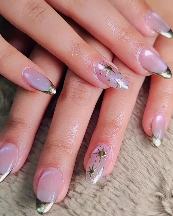 A celestial take on a classic French. These nails feature a sheer nude base with metallic gold tips, accented with delicate, hand-painted gold stars for a touch of magic.