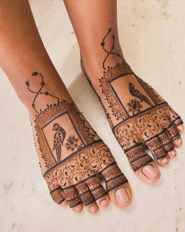 Foot mehndi can be so elegant. This engagement design features a unique parrot motif set within a decorative frame, with delicate chain details extending up the ankle for a beautiful, complete look.