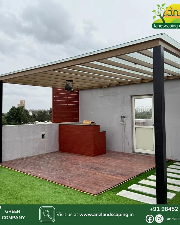 A modern pergola installation at a villa in Assetz Soul & Soil, Bangalore. This design features a powder-coated MS frame, toughened glass roofing, and a wood-finish deck with a bar counter.