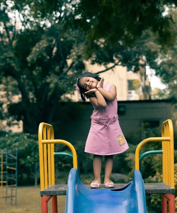 A full-of-life shot of my niece at the top of a slide in the park. I love capturing these playful, unposed moments that truly reflect a child's personality.