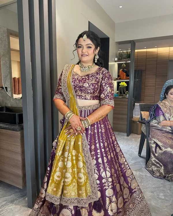A full view of this beautiful hairstyle. The half-updo is adorned with a statement hair accessory, and the rest of the hair is styled in loose waves, perfect for a wedding or reception.
