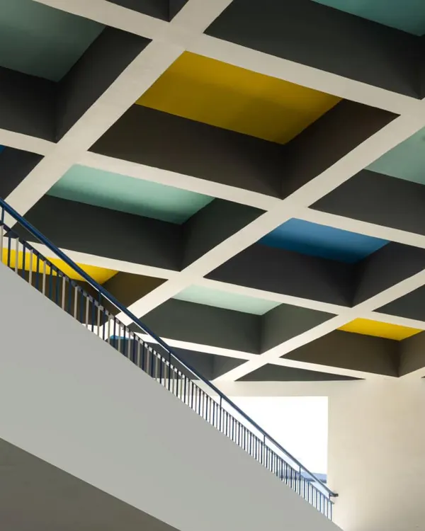 A colorful, coffered ceiling in a school designed by MySpace Architects adds a playful and stimulating element to the educational environment.