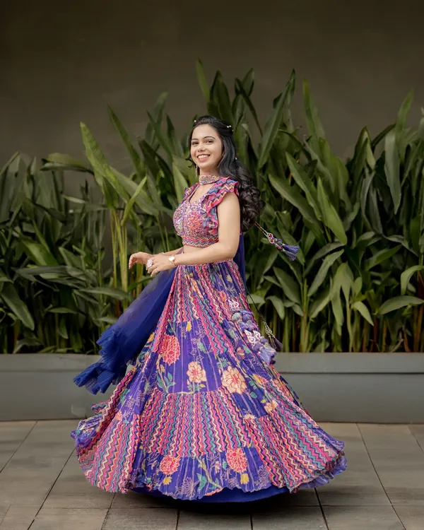 A joyful shot of the bride twirling in her vibrant sangeet lehenga. This photo is full of life, color, and movement.
