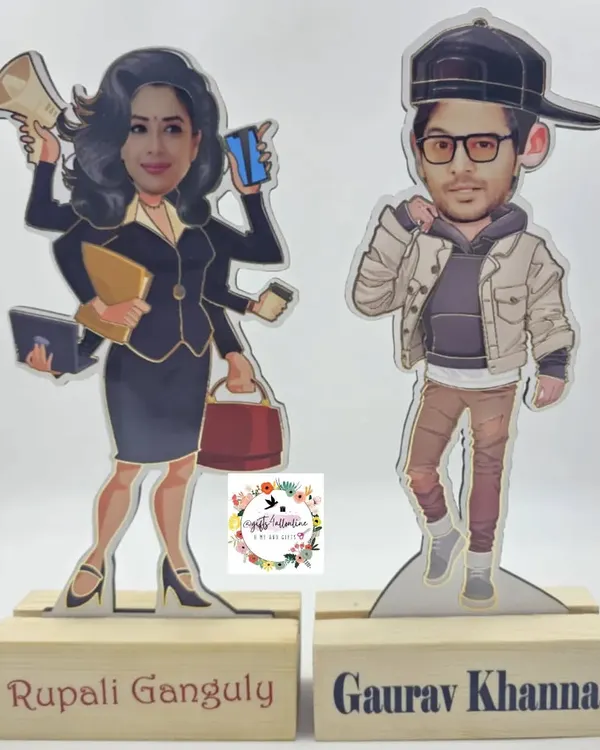 A pair of custom caricatures on wooden stands, featuring the actors from the show 'Anupama'. We can create these based on any photo.