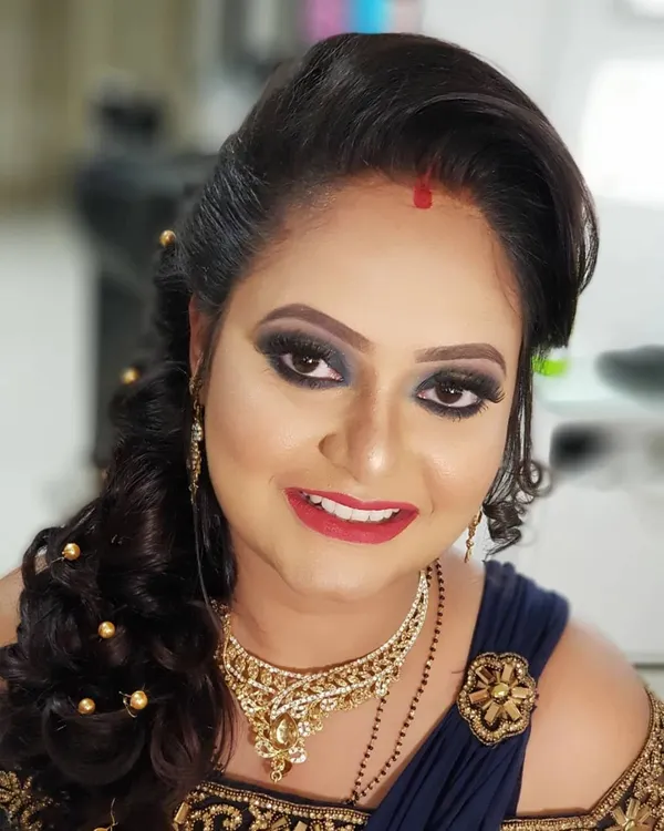 This reception look was all about drama and elegance. I created a bold smokey eye with a pop of gold and paired it with a classic red lip. The messy bun hairstyle with delicate hair accessories added a touch of modern romance.