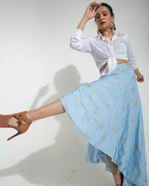A studio shot for Samoh India designed to capture movement in a static image. The model's dynamic pose and the flowing fabric of the skirt create a sense of energy and grace against a clean white backdrop.