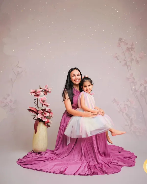 A magical mother-daughter portrait with a dreamy, whimsical theme. The matching gowns and the soft, starry background create a beautiful, storybook feel for this special bond.