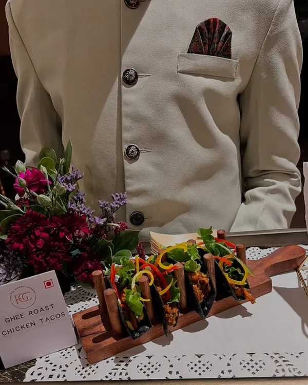 Our signature Ghee Roast Chicken Tacos served in a custom wooden holder. This appetizer is a perfect fusion of Indian flavors and a popular global format, showcasing our culinary creativity.