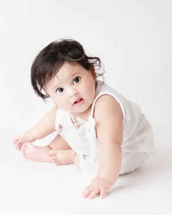 This little ball of snow is just perfect. An all-white, classic portrait like this is timeless and puts all the focus on the baby's adorable face and expression.