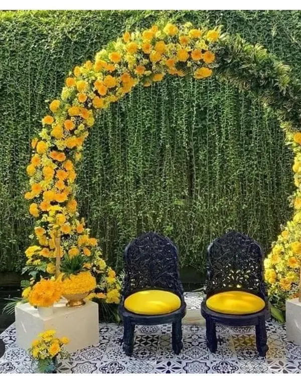 I designed this elegant Haldi ceremony seating with a beautiful arch of fresh yellow marigolds and lush greenery. The two ornate black chairs create a striking contrast, making it a perfect photo spot. I can create this kind of sophisticated outdoor wedding decor at your venue anywhere in the Delhi NCR region.