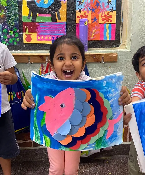 The excitement of showing off your creation is the best part of class! These colorful paper fish were made by layering shapes, a great exercise in planning and coordination for our 3.5 to 5-year-old artists.