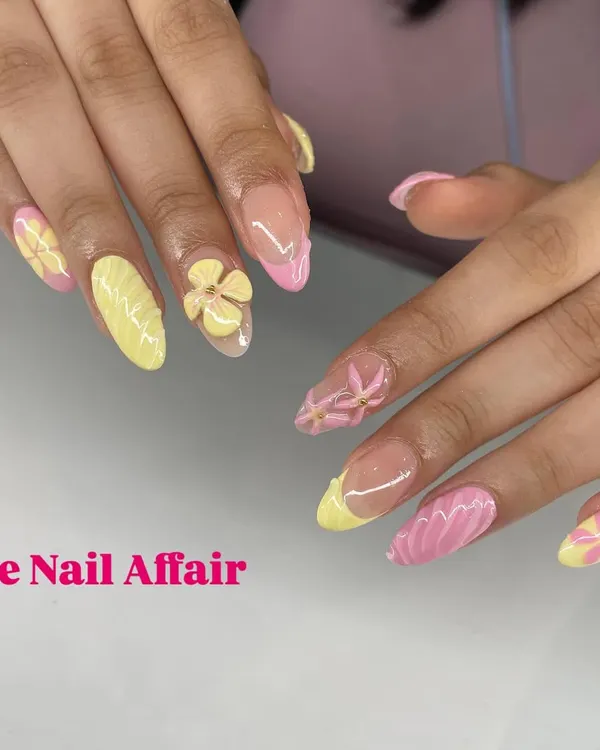 A sweet and summery set featuring a mix of yellow and pink nails, adorned with hand-sculpted 3D flowers and textured details.