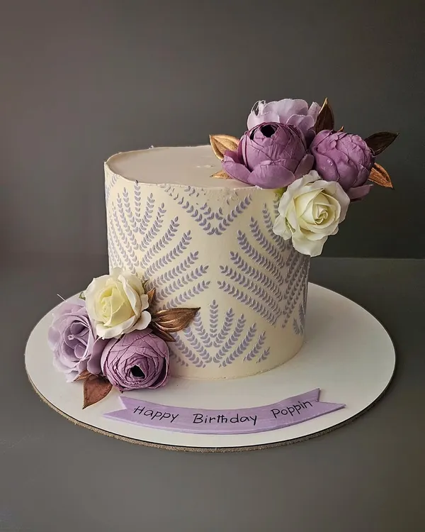 You can never go wrong with lilac. A beautiful chocolate truffle cake with a delicate stencil pattern and an arrangement of lilac and white sugar flowers.