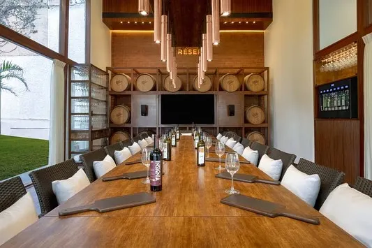 Welcome to the 'Cave de la Reserve' at my Grover Zampa Experience Centre. This private tasting room, with its long wooden table and backdrop of wine barrels, is the perfect setting for an exclusive and intimate gathering.