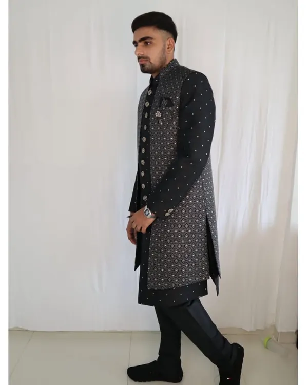 This outfit showcases a modern, layered approach to ethnic wear. A stylish grey printed long jacket is worn over a classic black kurta, creating a sharp and contemporary look perfect for any wedding function.