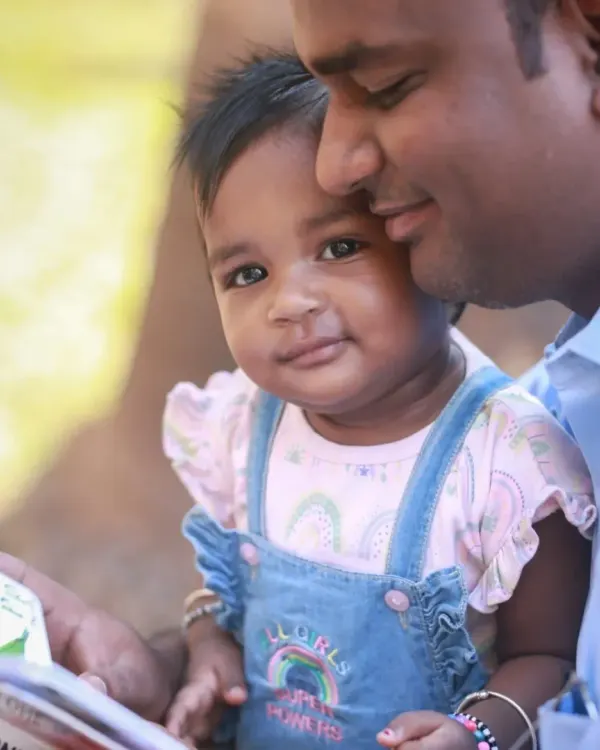 A father and daughter sharing a quiet moment reading a book together. This is the kind of authentic, love-filled interaction I aim to capture in my lifestyle family sessions.