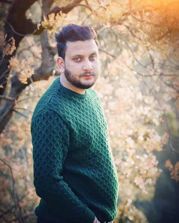 A candid-style male portrait taken outdoors with beautiful backlighting. This type of shot is great for a professional portfolio or social media, conveying a natural and confident look.