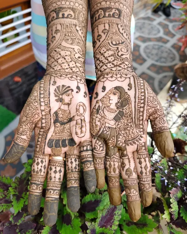 A close-up of custom bride and groom portraits on the palms. This is a popular choice for brides who want their mehendi to be a true reflection of their wedding.