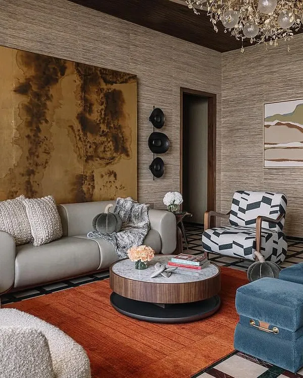 In this living area, I used a natural grasscloth wallpaper to create a backdrop of warmth and texture. The design harmonizes with the bold furniture and rich color palette, resulting in a space that feels both curated and invitingly livable.