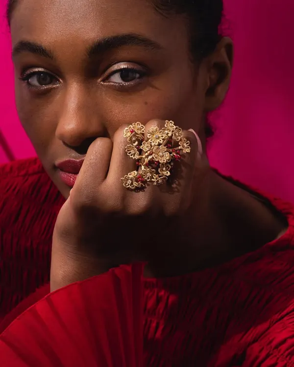A model wearing my show-stopping cherry blossom ring. This piece is a sculpture for the hand, with branches of 18k gold flowers and ruby "cherries" wrapping around multiple fingers, inspired by the beauty of spring.